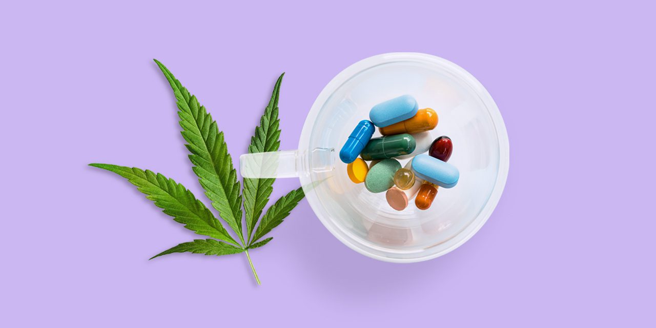 top view of various pills inside a plastic cup beside a cannabis leaf in purple background