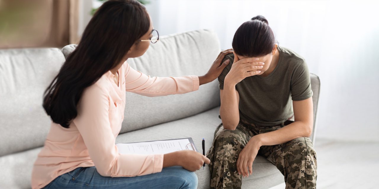 a woman comforting/counseling another woman in military uniform