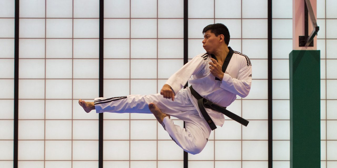 a man in martial arts outfit doing flying kick