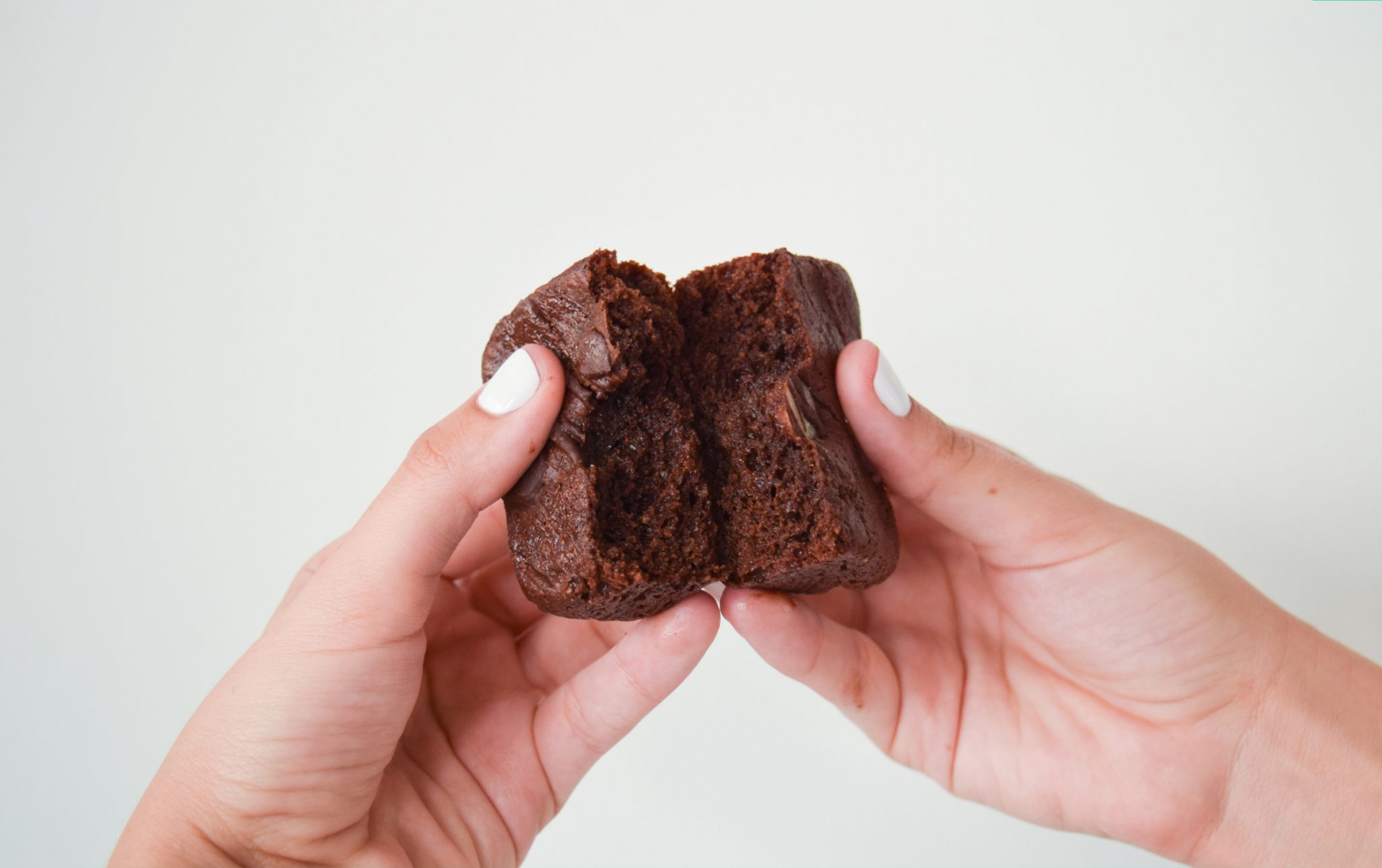 closeup hand breaking a brownie into two