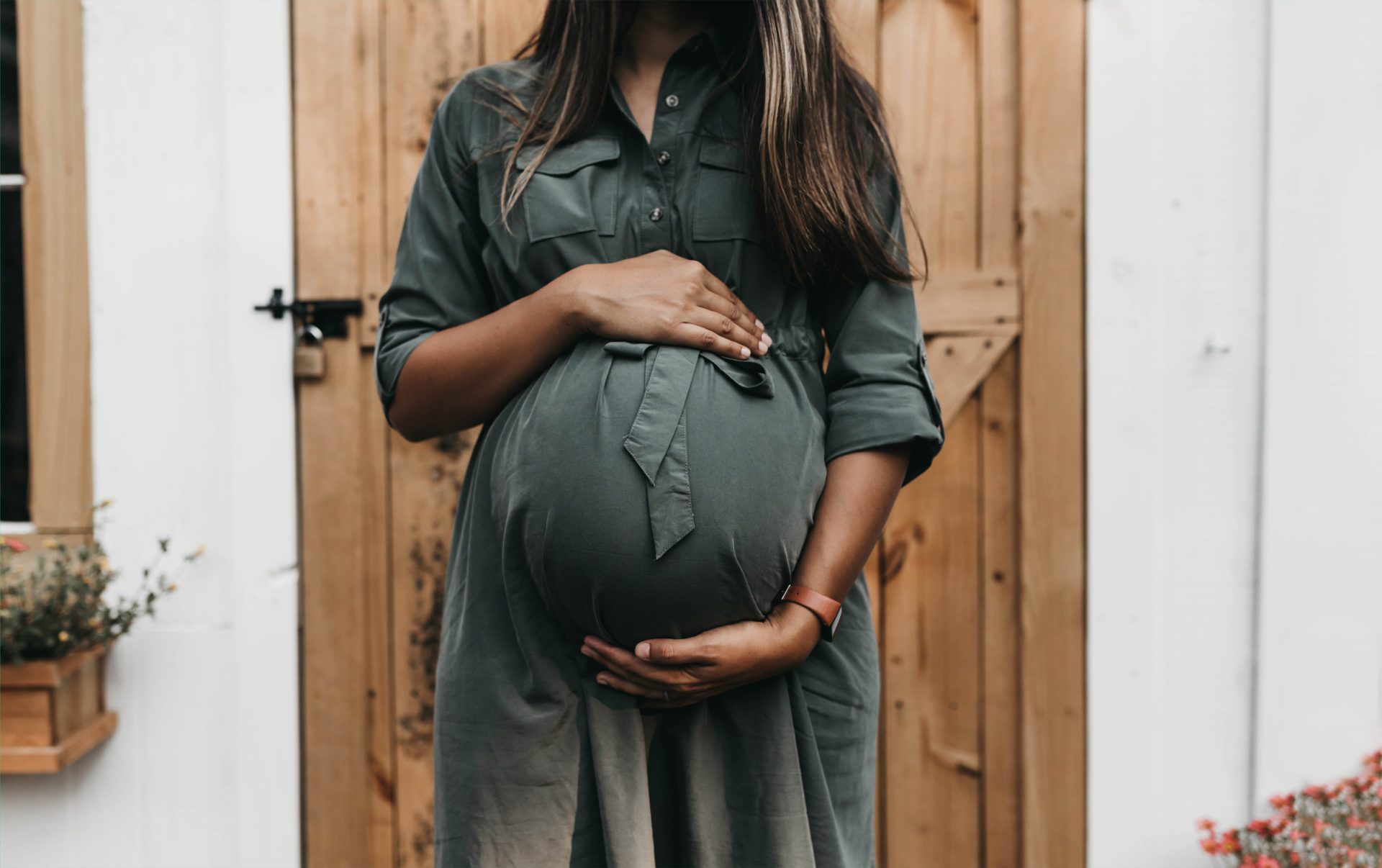 pregnant woman standing infront of a door