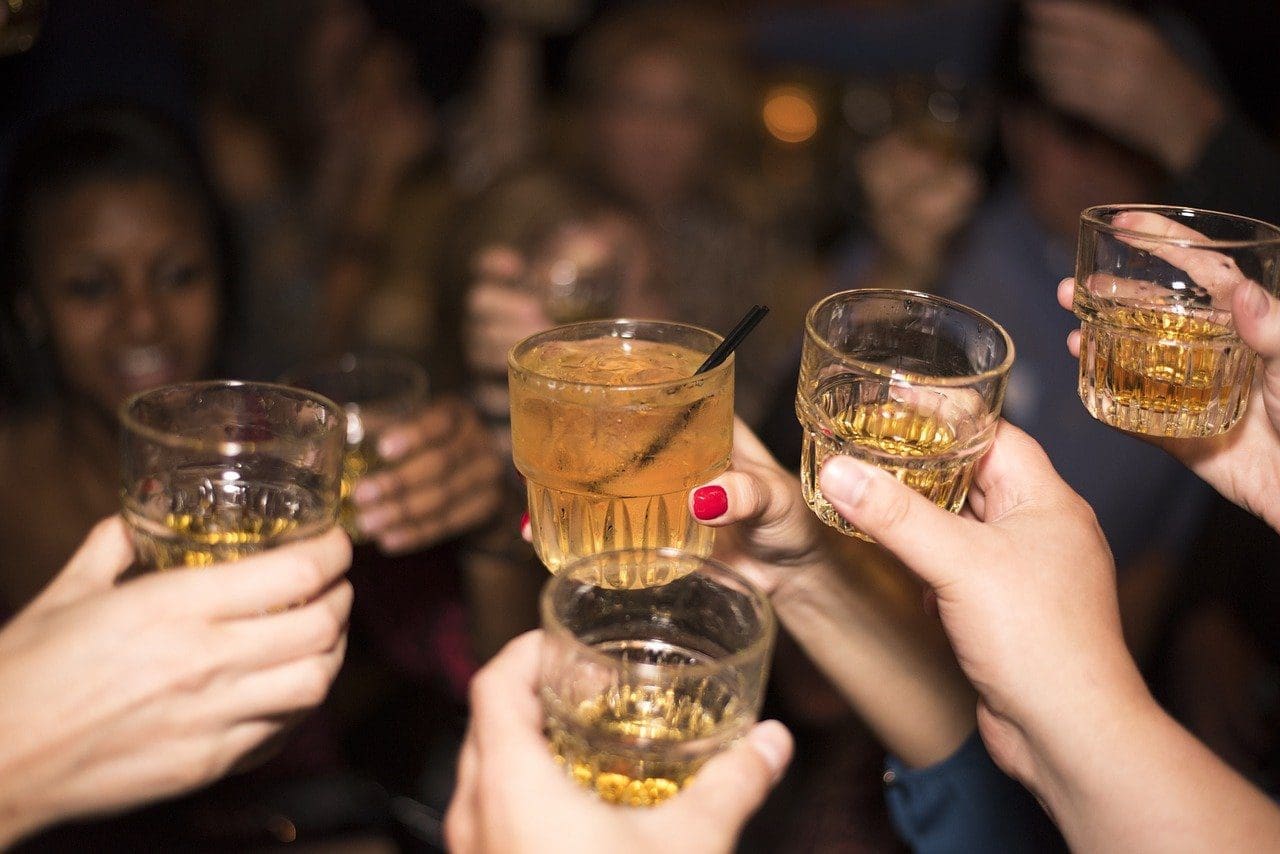 A cheers or salute being made with glasses of alcohol.