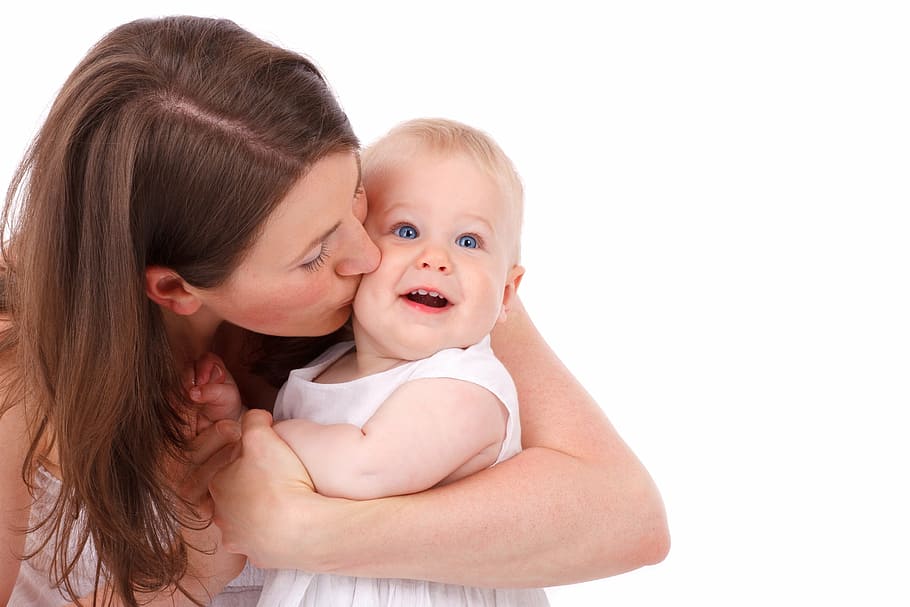 A child needs to have a caregiver in order to qualify for a medical marijuana card. A picture of a mother holding and kissing her child.