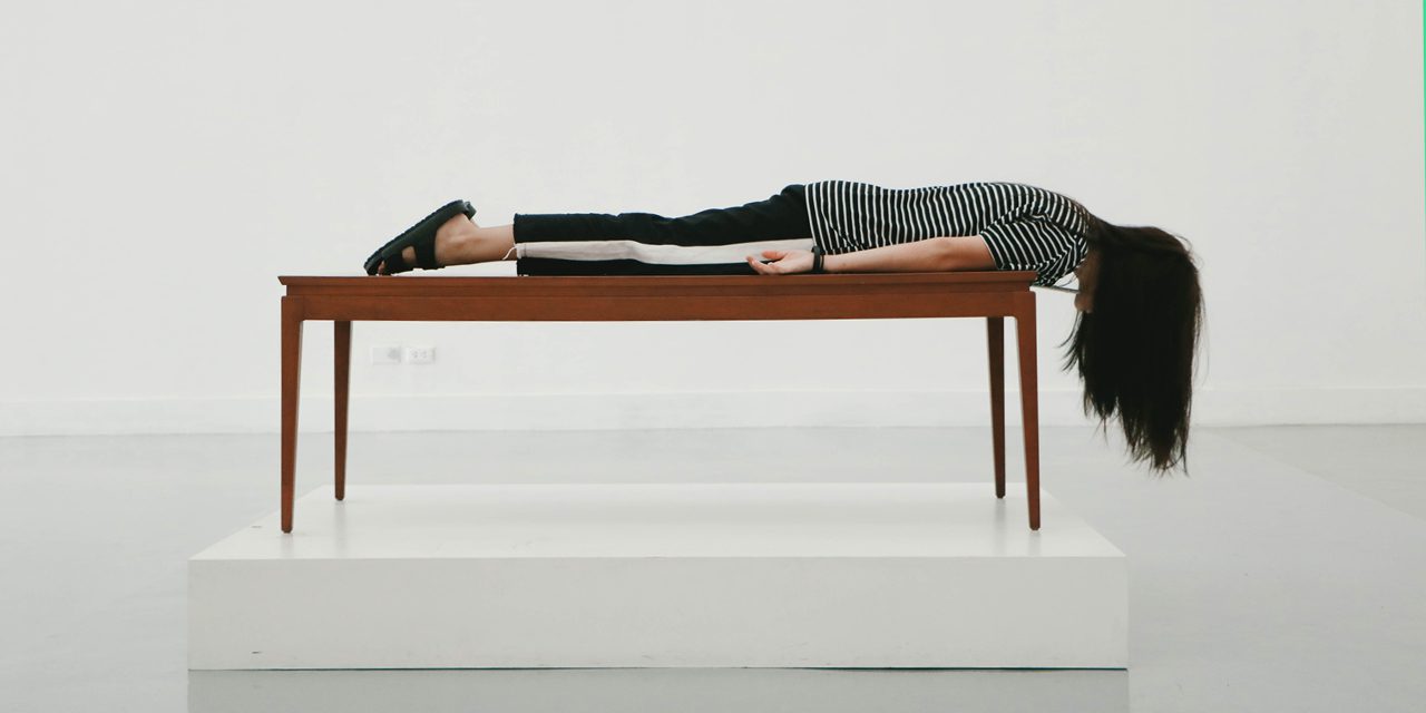 a woman lying on her front on the table with hair hanging