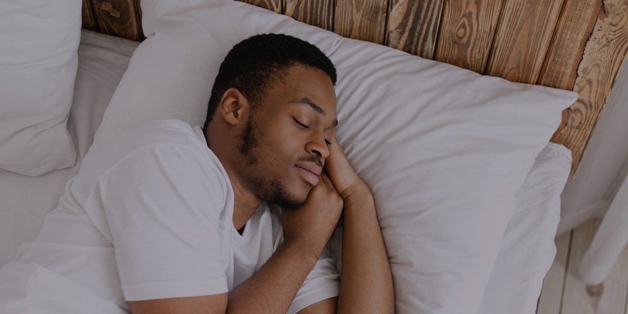 man sleeping soundly on his bed