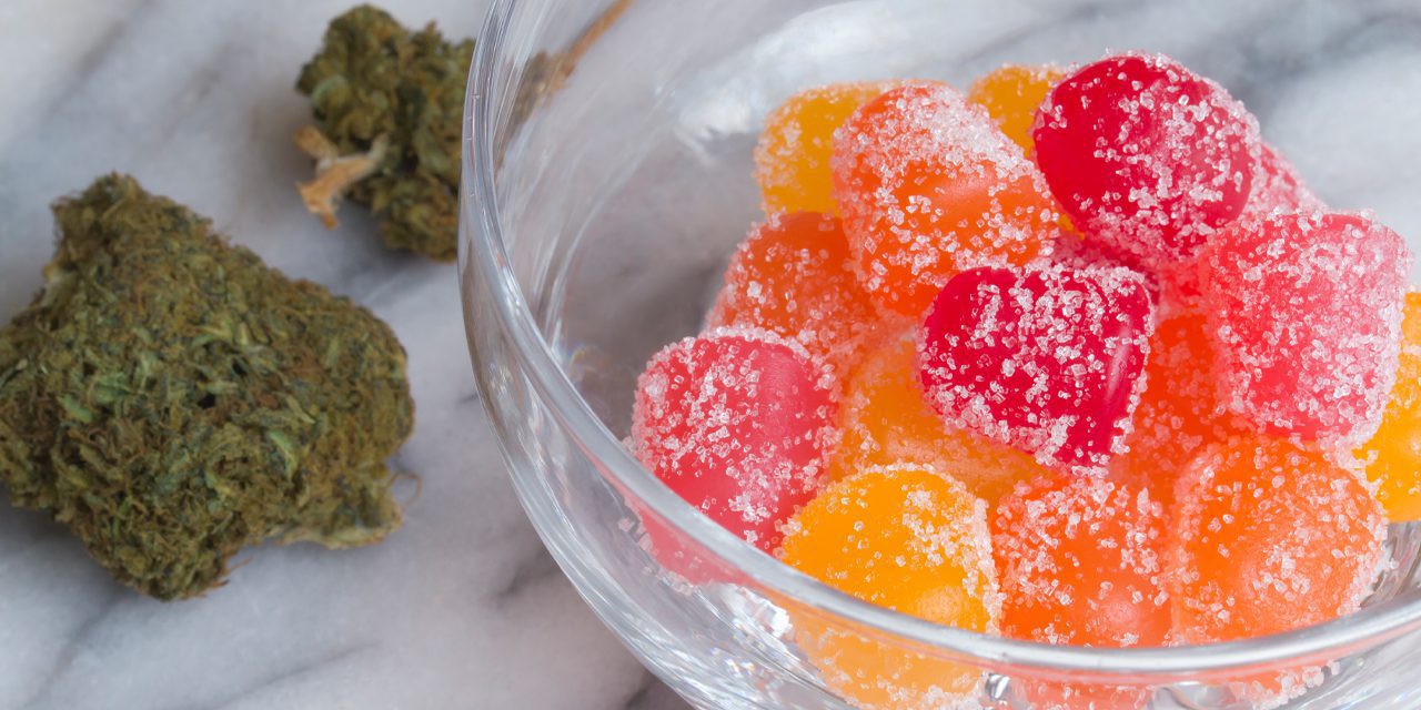 weed chunk beside a bowl of gummies