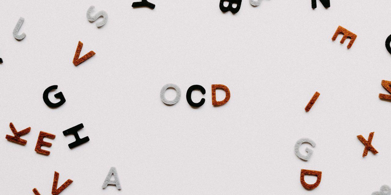 letters made of felt cloth spelled as OCD and scattered random letter around it