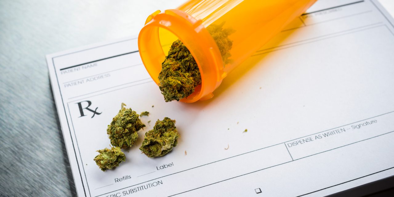 cannabis in prescription bottle over a prescription pad
