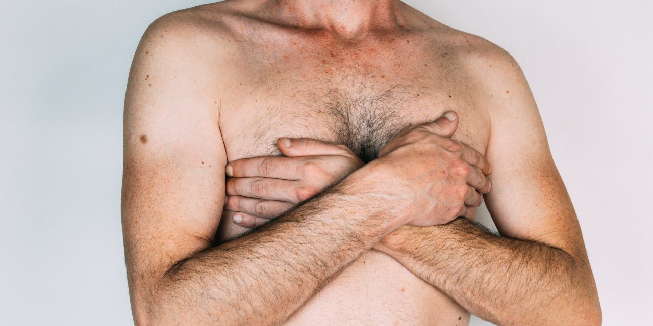 half part body of a man while covering his breast