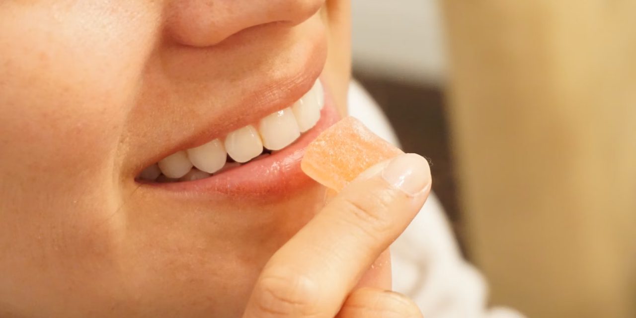close up of woman's mouth eating candy